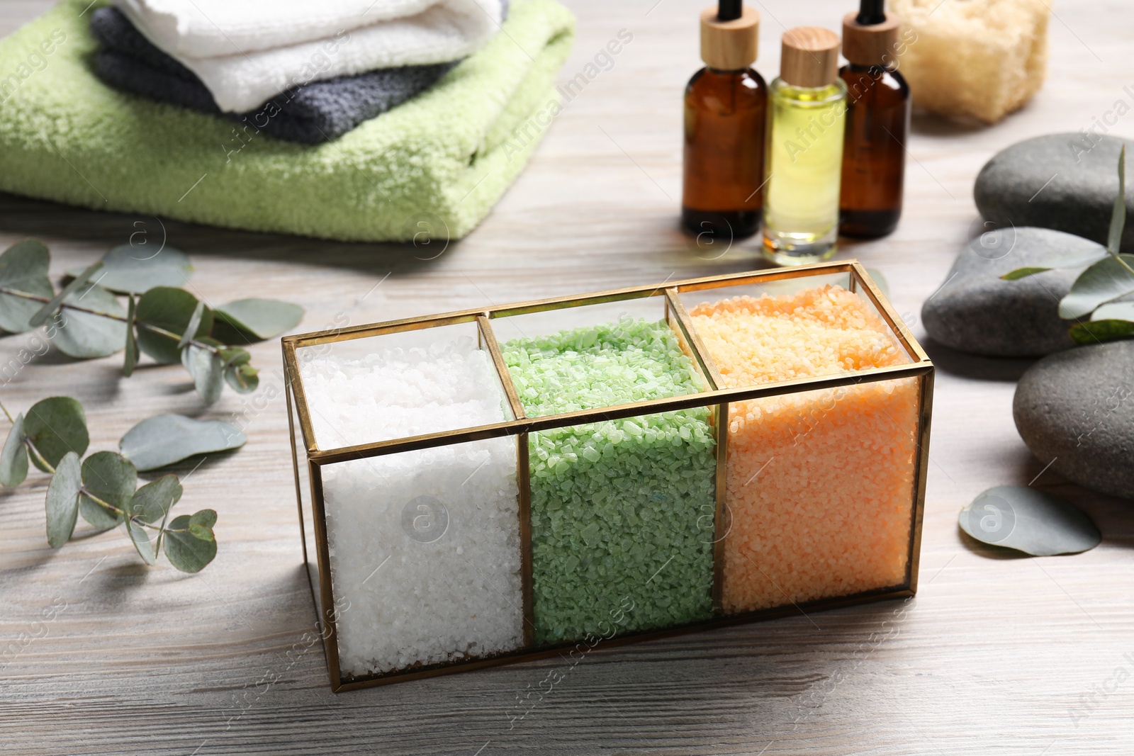 Photo of Different types of sea salt, spa products and eucalyptus branches on wooden table
