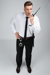 Photo of Male security guard using portable radio transmitter on color background