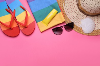 Photo of Flat lay composition with sunscreen and beach accessories on pink background. Space for text