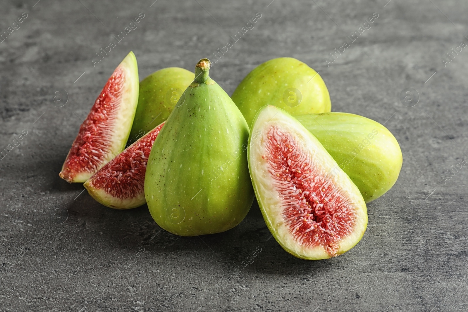 Photo of Fresh ripe figs on gray background. Tropical fruit