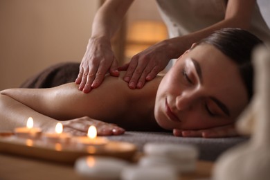 Spa therapy. Beautiful young woman lying on table during massage in salon, closeup