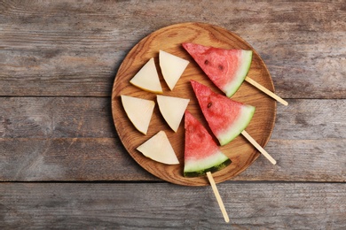 Watermelon and melon slices on wooden background, flat lay