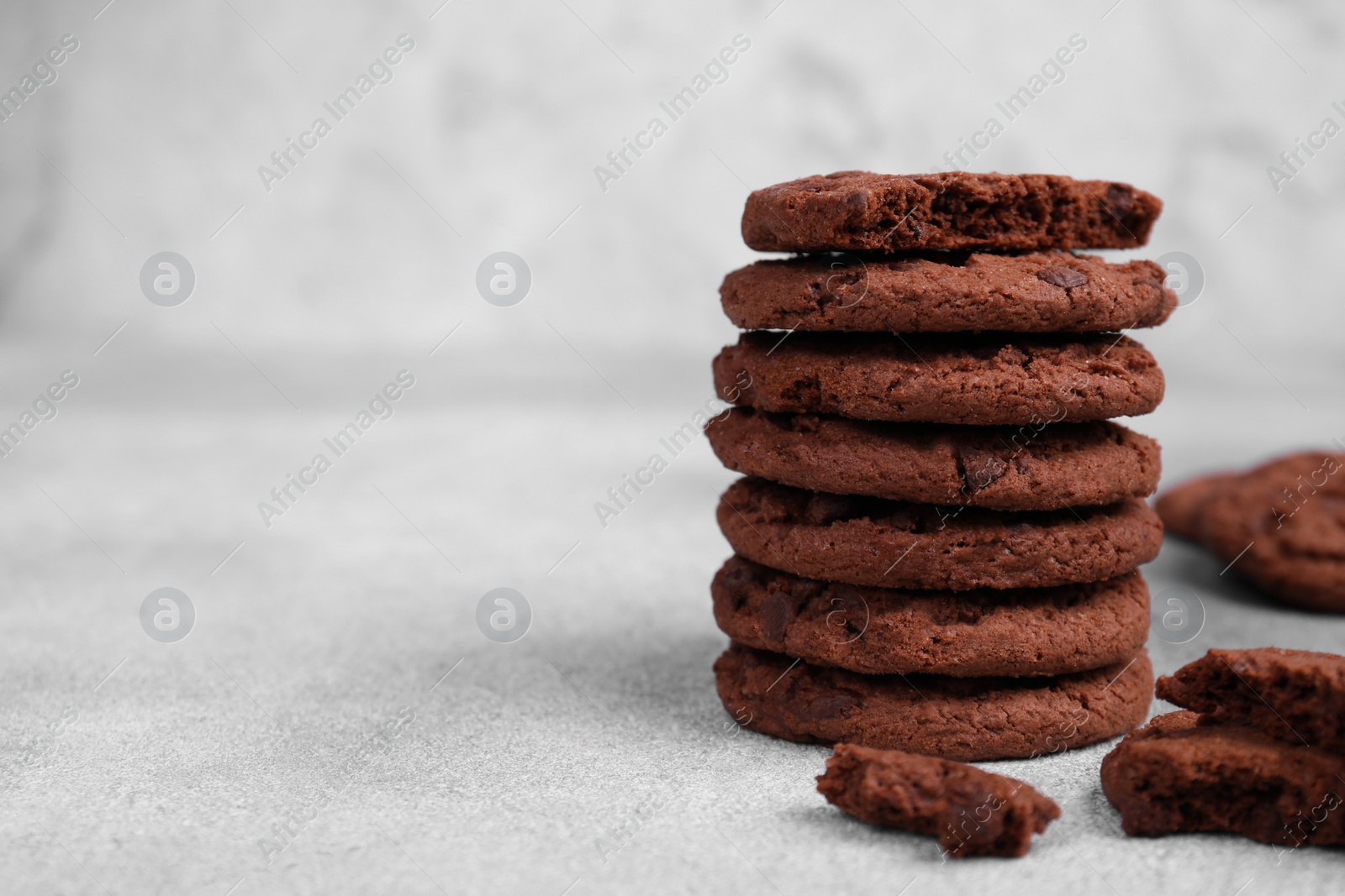 Photo of Tasty chocolate cookies on light grey table, closeup. Space for text