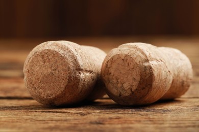 Photo of Corks of wine bottles on wooden table, closeup