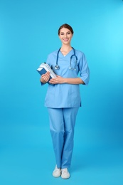 Photo of Young medical student with books on color background