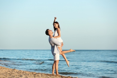 Photo of Happy young couple having fun at beach on sunny day