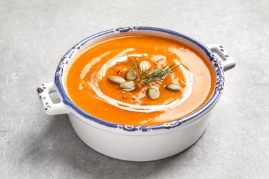 Bowl of tasty sweet potato soup with pumpkin seeds on table