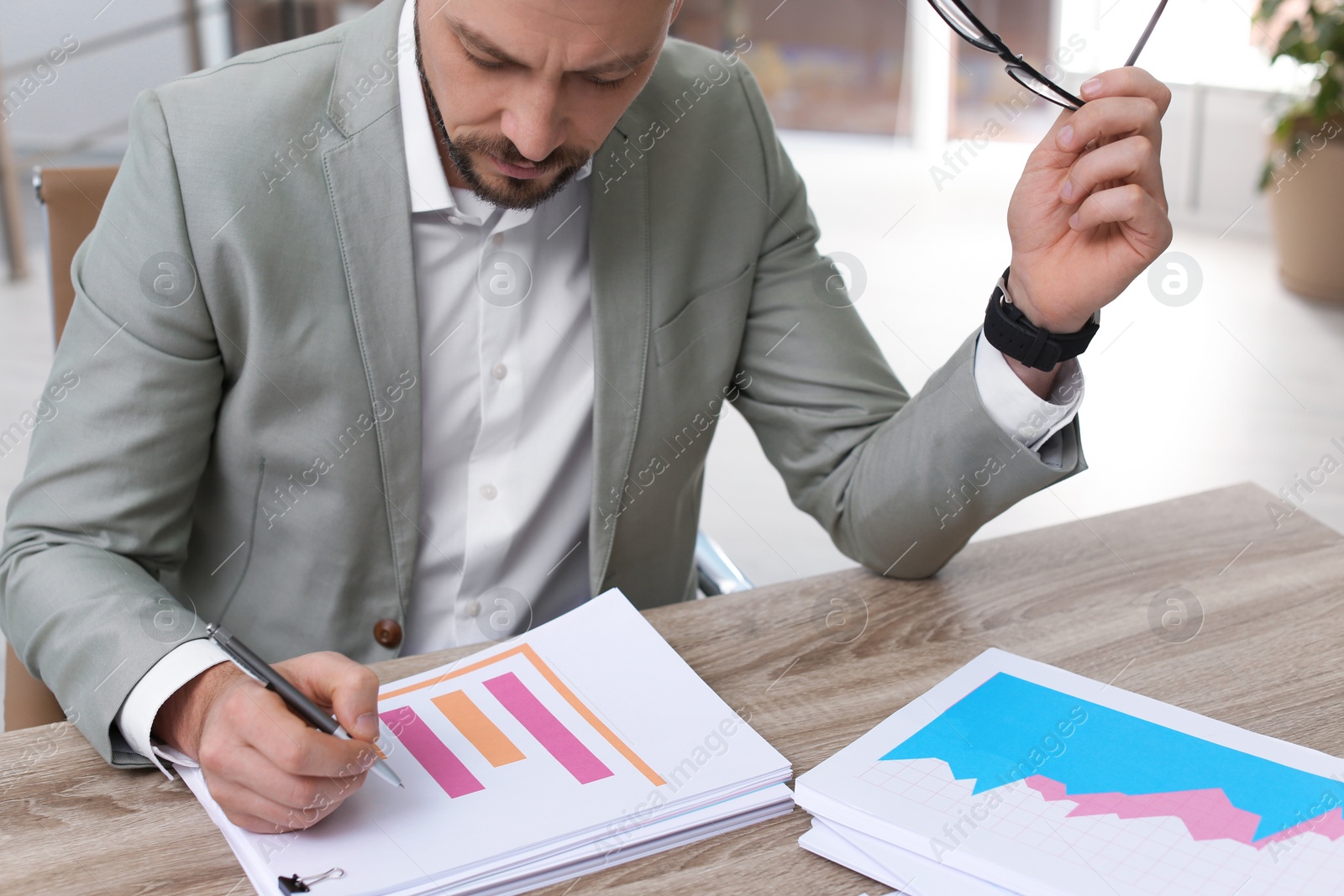 Photo of Businessman working with documents at table in office