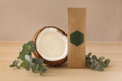Photo of Scented sachet, eucalyptus branches and coconut on wooden table