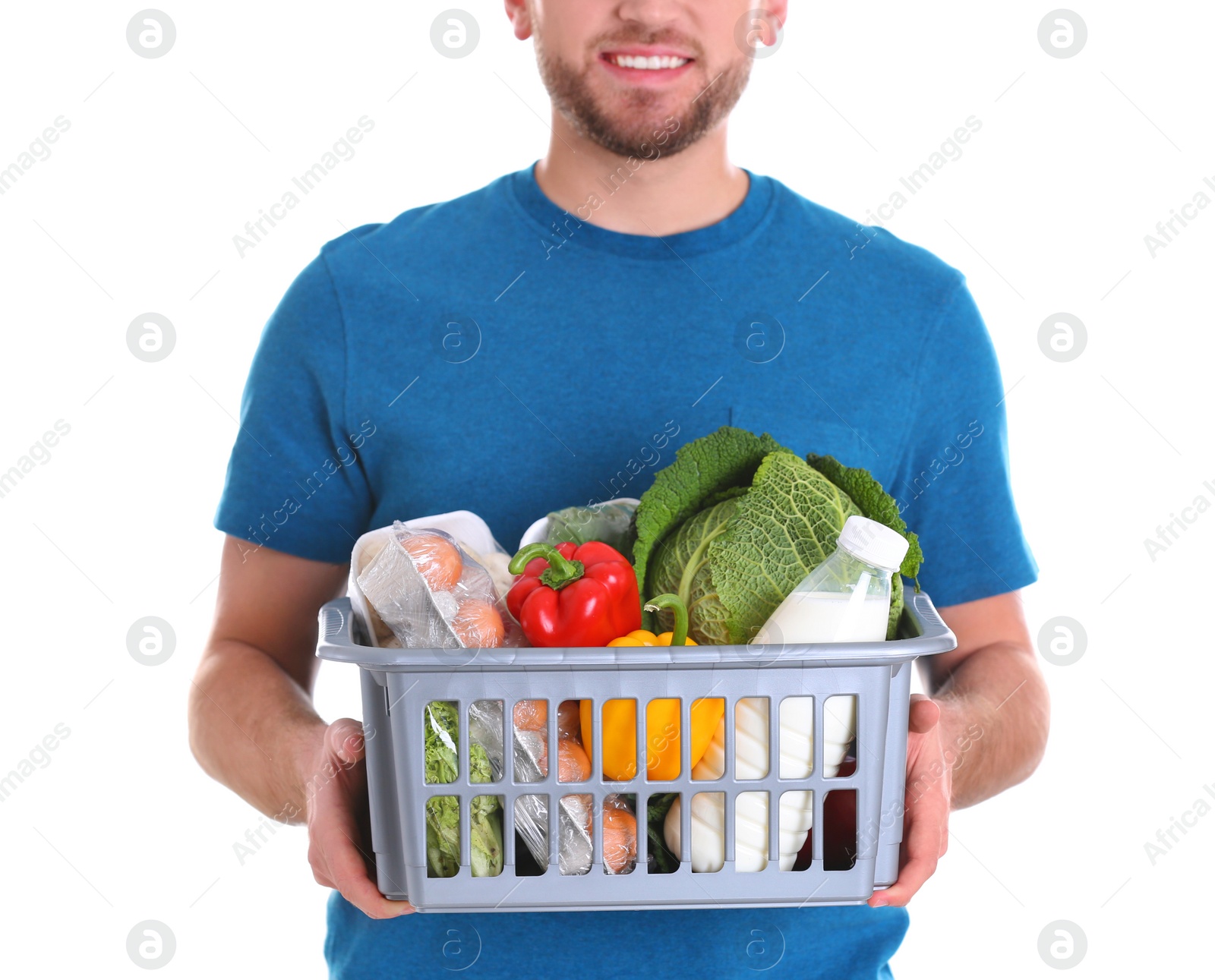 Photo of Delivery man holding plastic crate with food products on white background, closeup