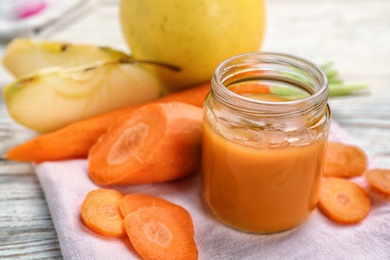 Photo of Jar with healthy baby food and ingredients on table