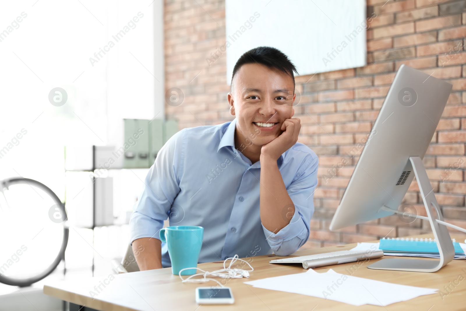 Photo of Happy young businessman enjoying peaceful moment at workplace