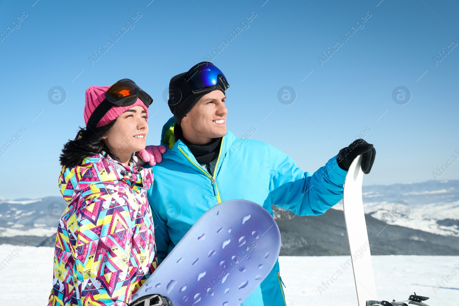Photo of Happy couple with snowboards in mountains. Winter vacation