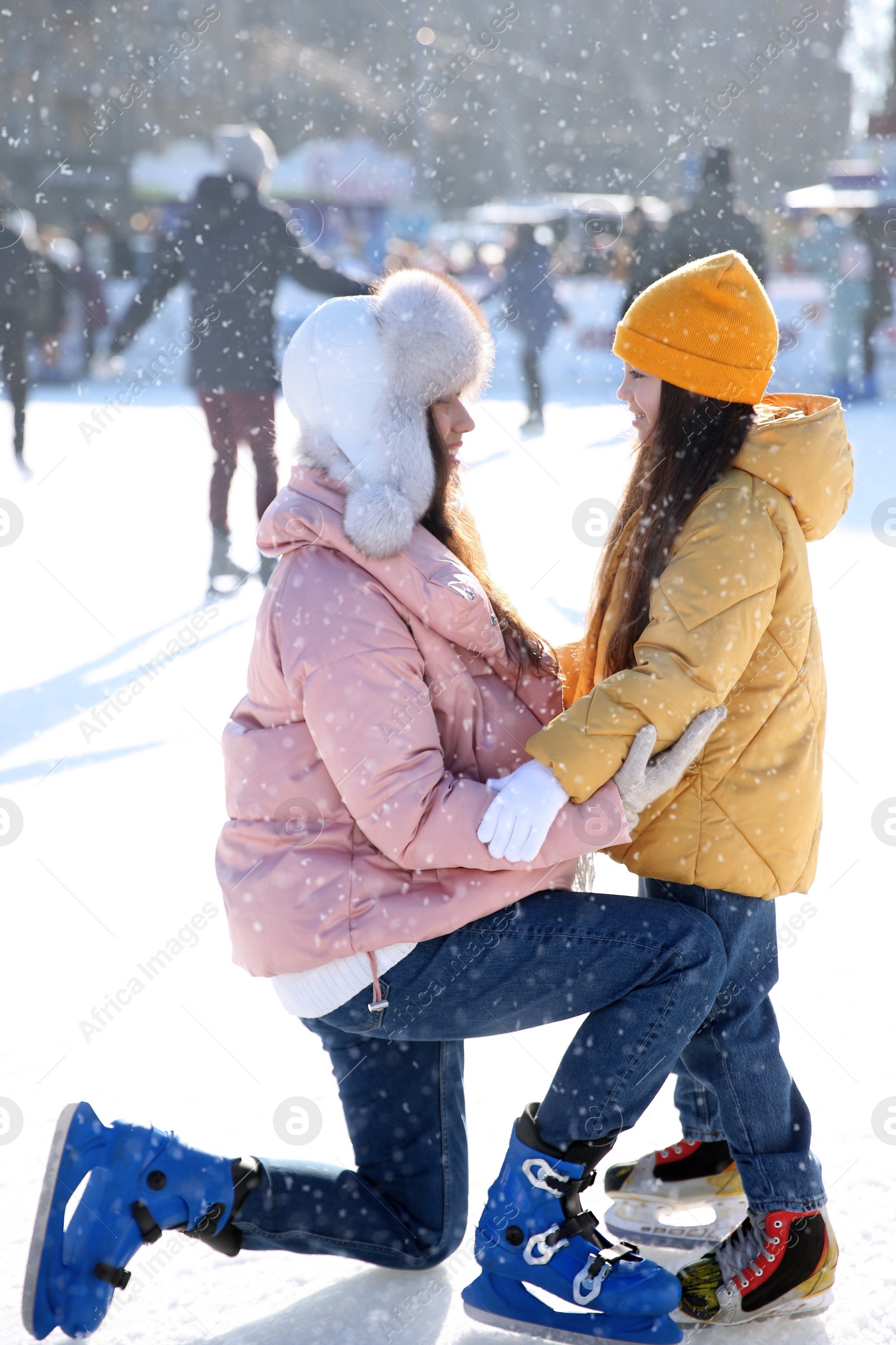 Image of Mother and daughter spending time together at outdoor ice skating rink