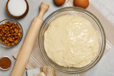 Photo of Fresh yeast dough and ingredients for cake on marble table, flat lay