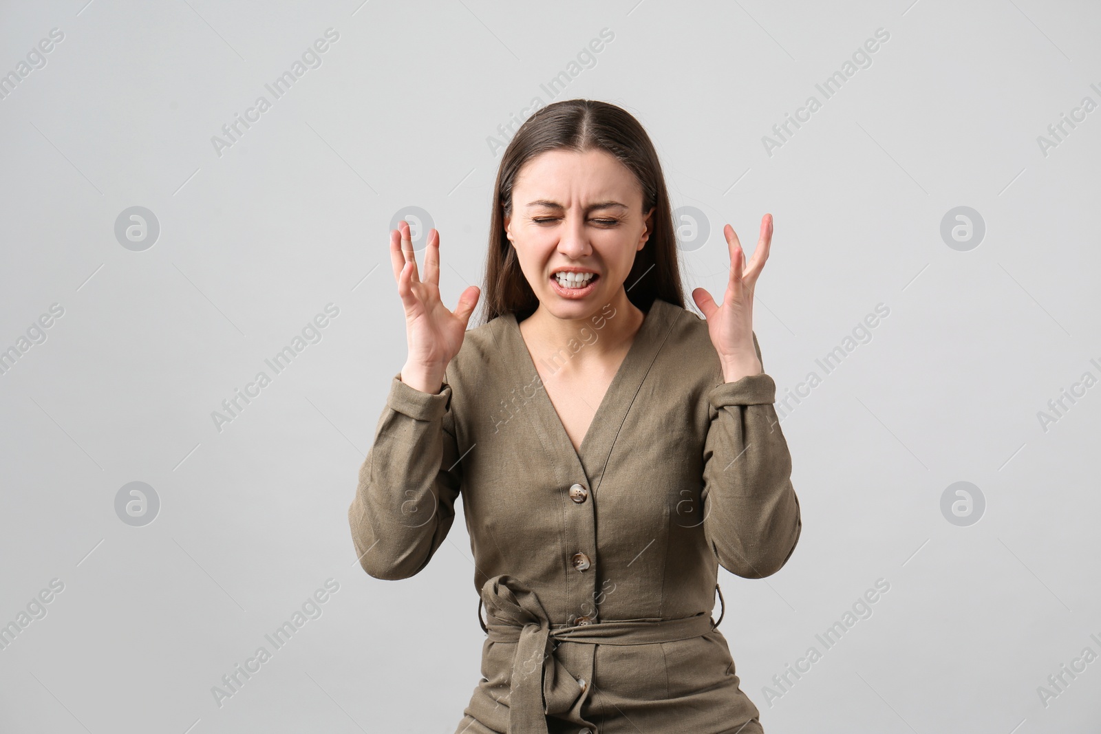 Photo of Portrait of emotional young woman on light grey background. Personality concept