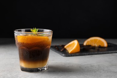 Photo of Tasty refreshing drink with coffee and orange juice on grey table, space for text