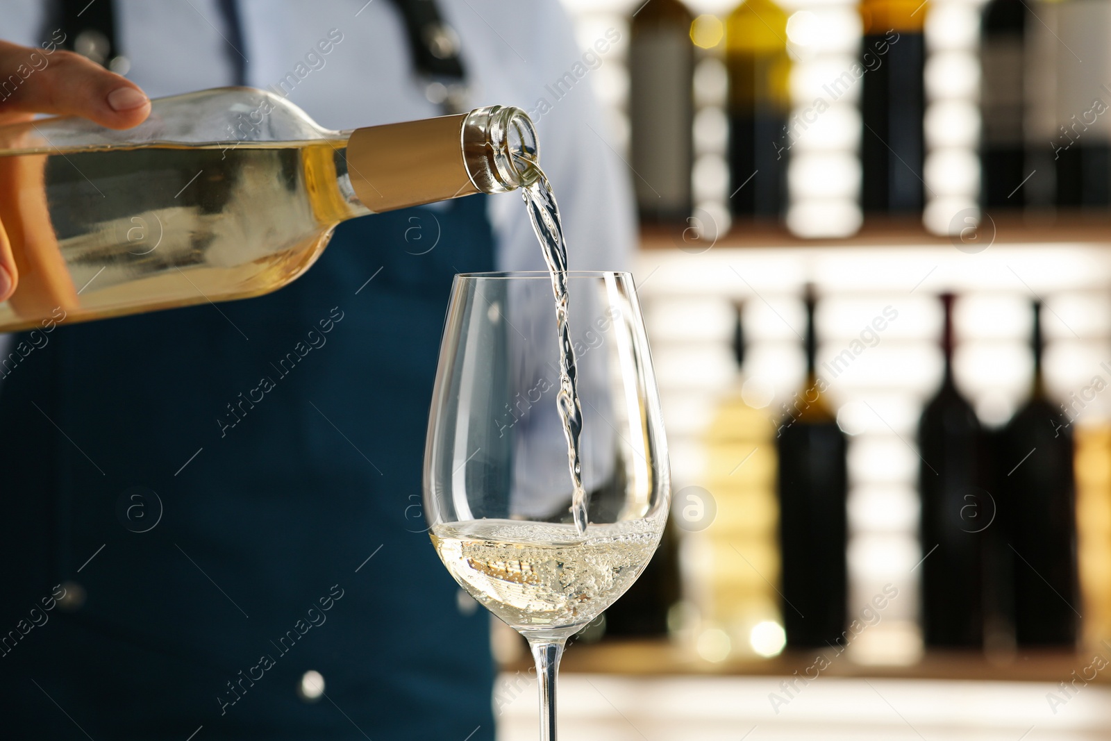 Photo of Bartender pouring wine into glass in restaurant, closeup