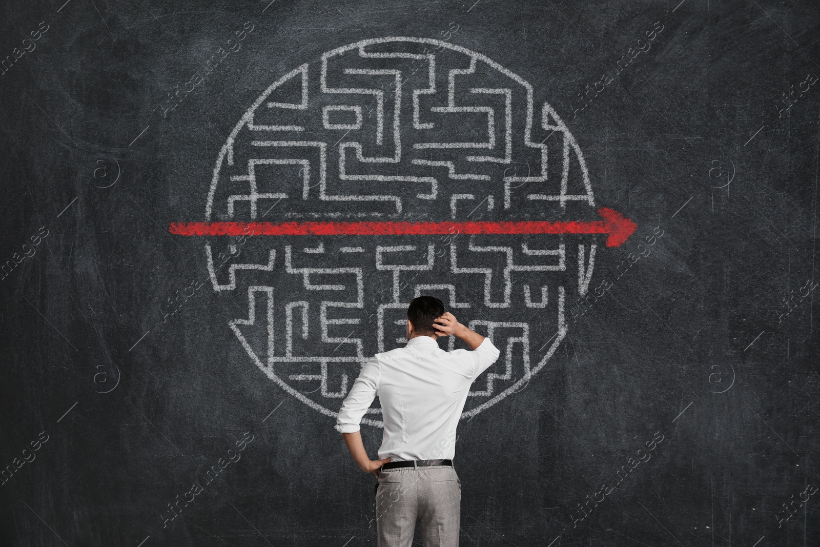 Image of Businessman looking at chalkboard with illustration of maze