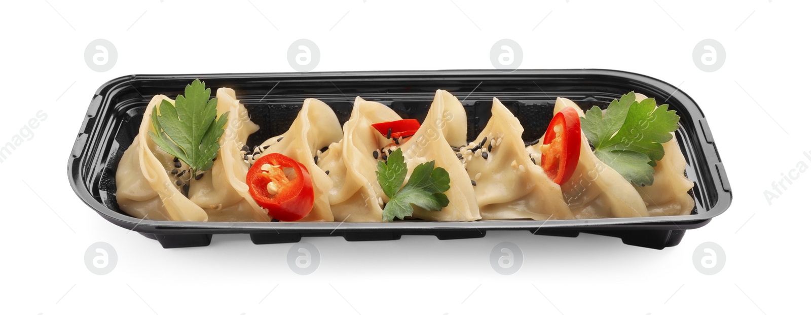 Photo of Delicious gyoza (asian dumplings) with sesame, parsley and pepper isolated on white