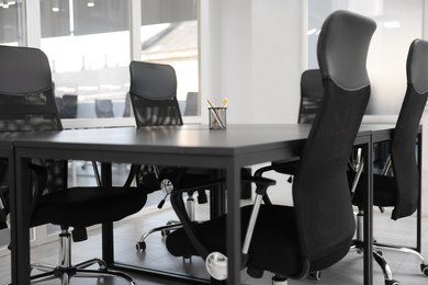 Photo of Comfortable office chairs and tables in meeting room