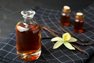 Photo of Aromatic homemade vanilla extract on table, closeup. Space for text