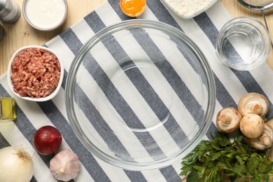 Photo of Bowl and different products on wooden table, flat lay