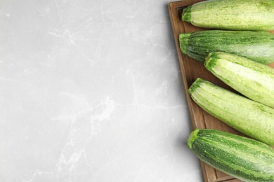 Photo of Fresh ripe green zucchinis on light table, top view. Space for text