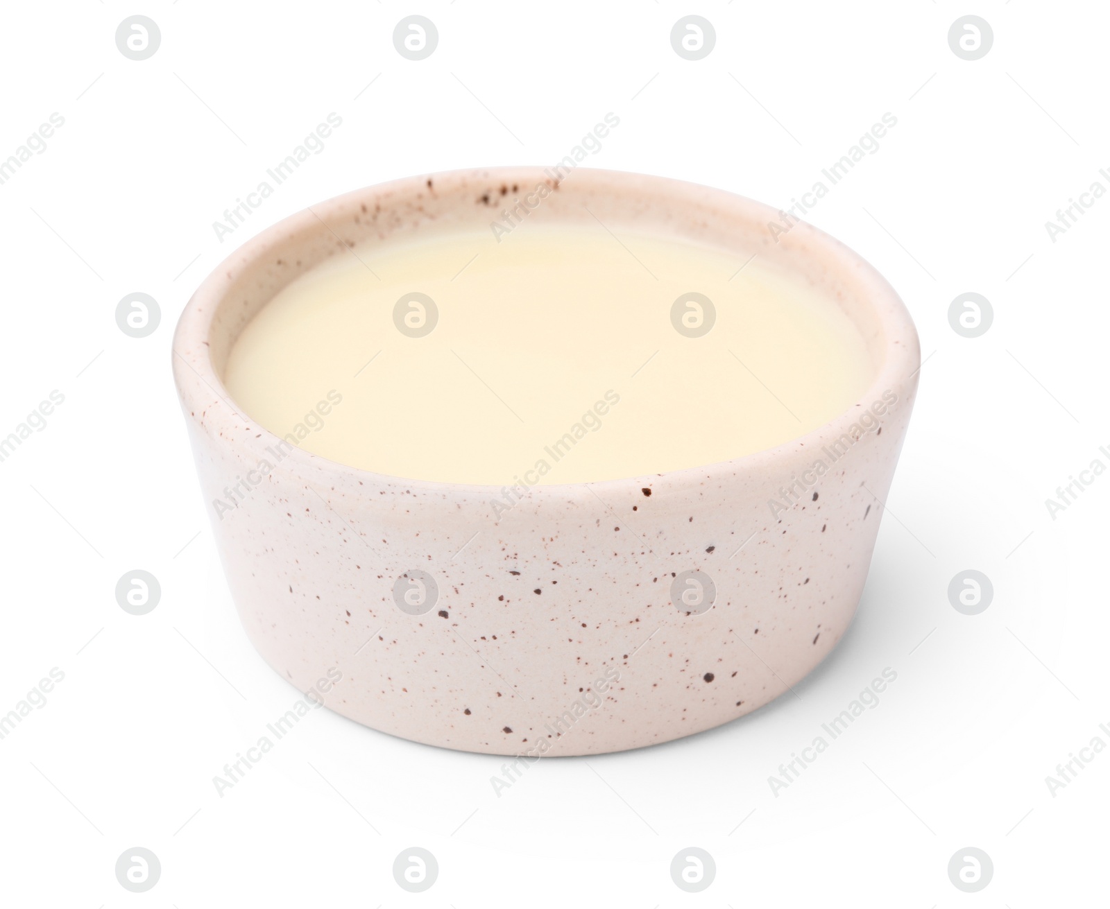 Photo of Bowl with condensed milk isolated on white