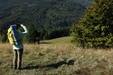 Photo of Tourist with backpack enjoying view in mountains on sunny day