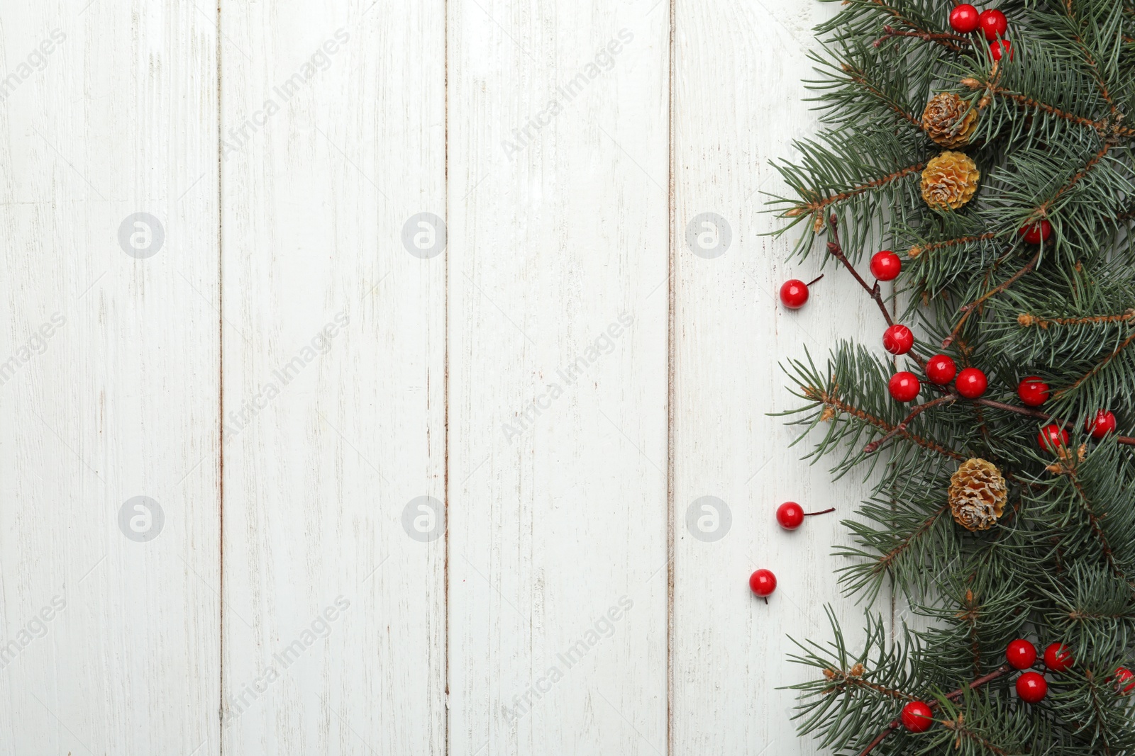 Photo of Flat lay composition with fir branches and berries on white wooden background, space for text. Winter holidays
