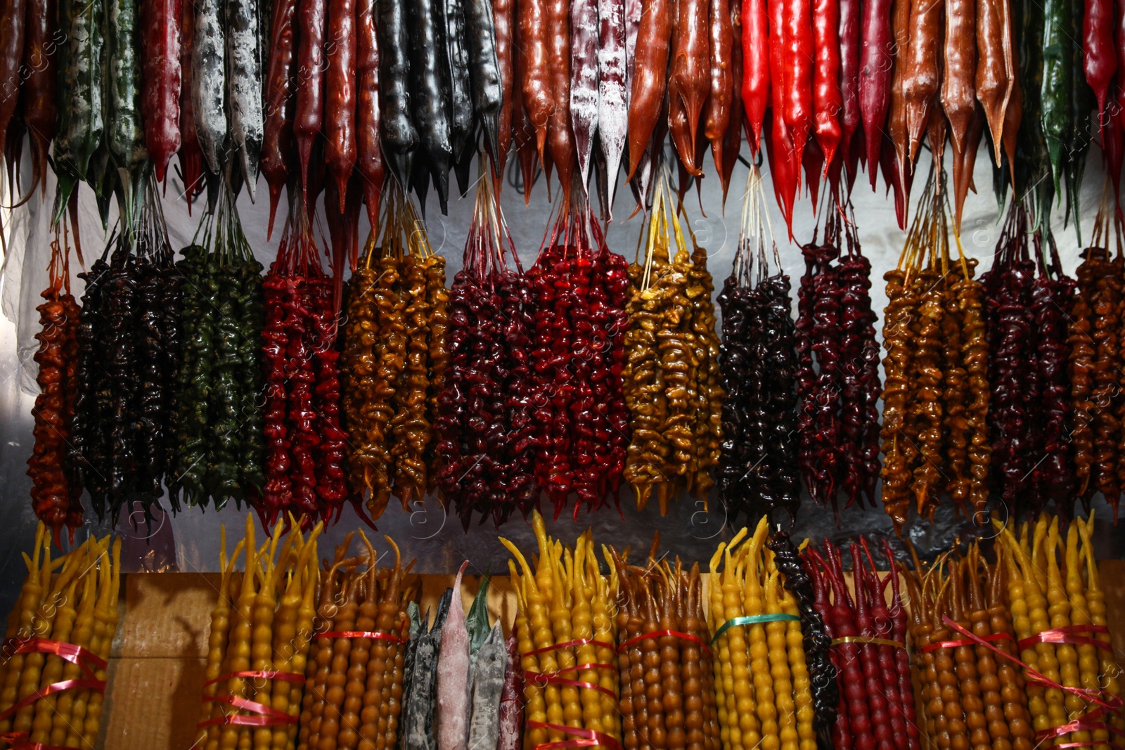 Photo of Bunches of different delicious churchkhelas at market