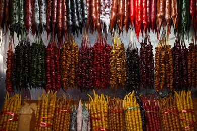 Photo of Bunches of different delicious churchkhelas at market