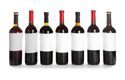 Photo of Bottles with red wine on white background