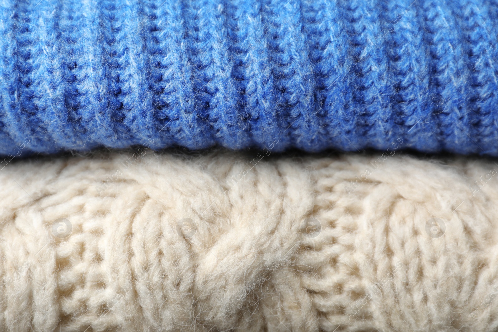 Photo of Stack of folded warm knitted sweaters, closeup