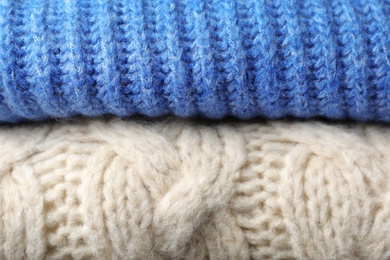 Photo of Stack of folded warm knitted sweaters, closeup