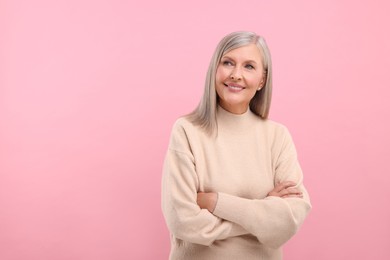 Photo of Portrait of beautiful middle aged woman on pink background, space for text