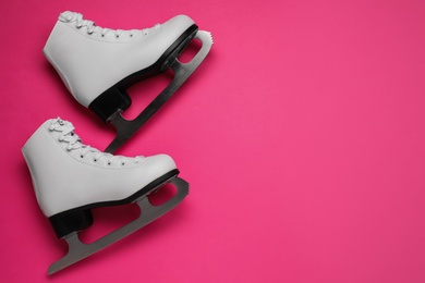 Photo of Pair of figure ice skates on pink background, flat lay. Space for text