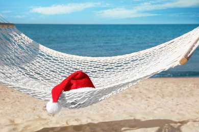 Photo of Rope hammock with Santa's hat on beach. Christmas vacation