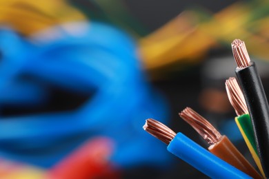 Photo of New colorful electrical wires on blurred background, closeup. Space for text