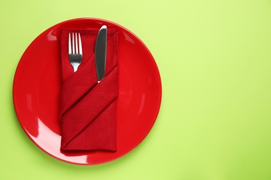 Stylish table setting on light green background, top view