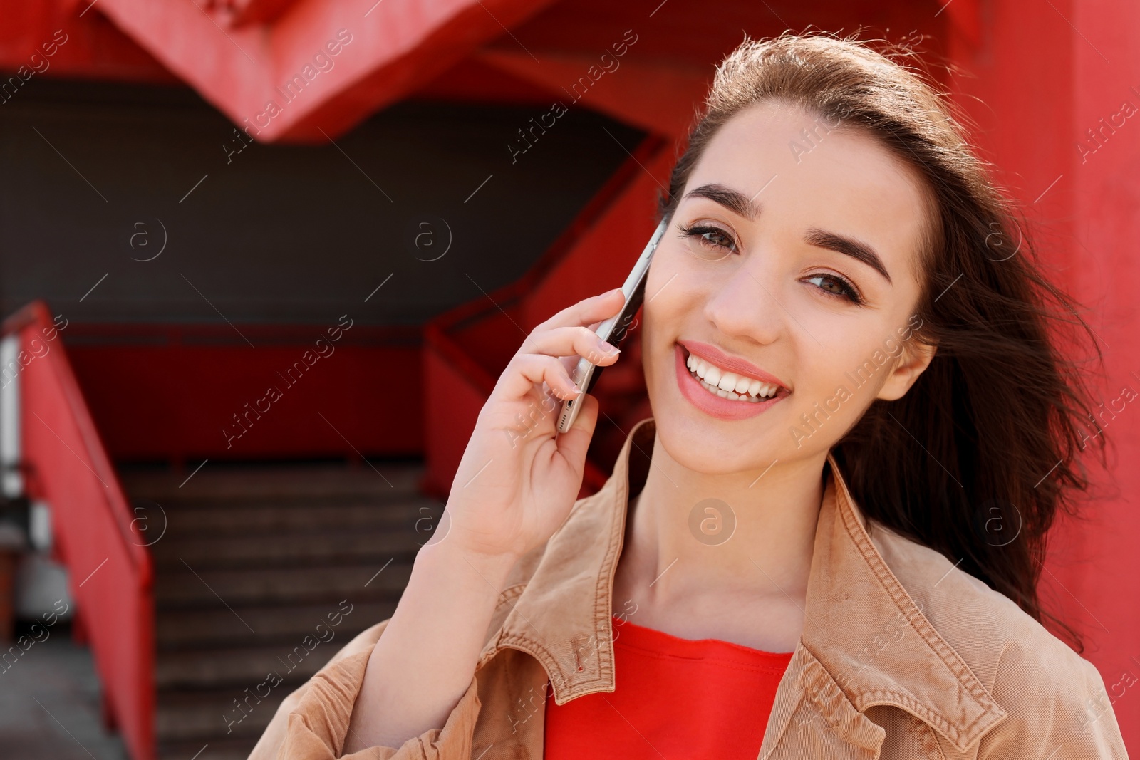 Photo of Young woman talking on mobile phone outdoors