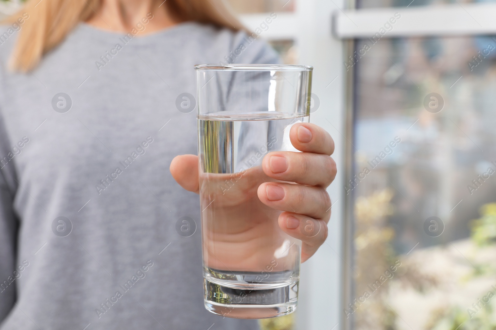 Photo of Woman holding glass of pure water, closeup