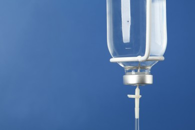 IV infusion set on blue background, closeup. Space for text