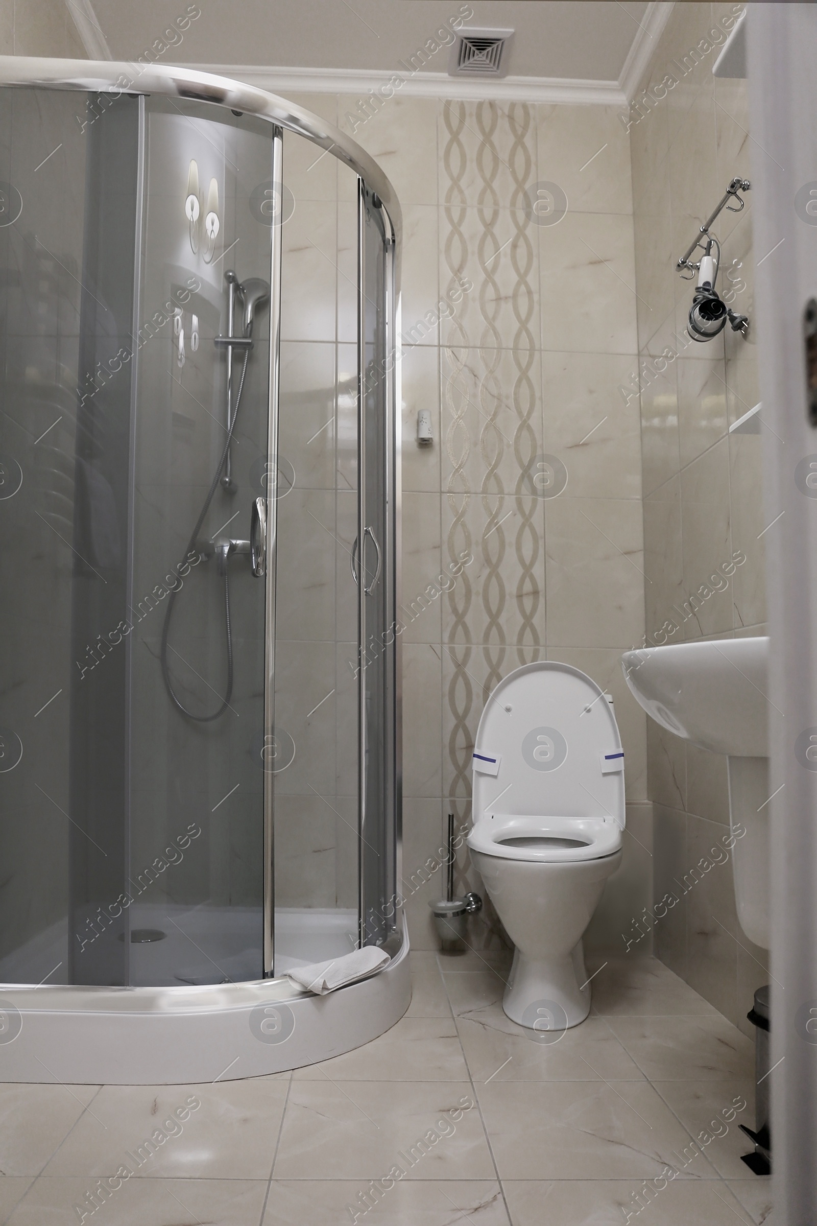 Photo of Modern bathroom interior with clean toilet bowl and shower cabin