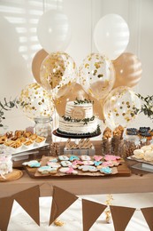 Baby shower party. Different delicious treats on wooden table and decor indoors