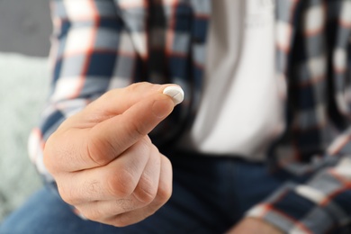 Photo of Man holding pill in hand, closeup view. Health care