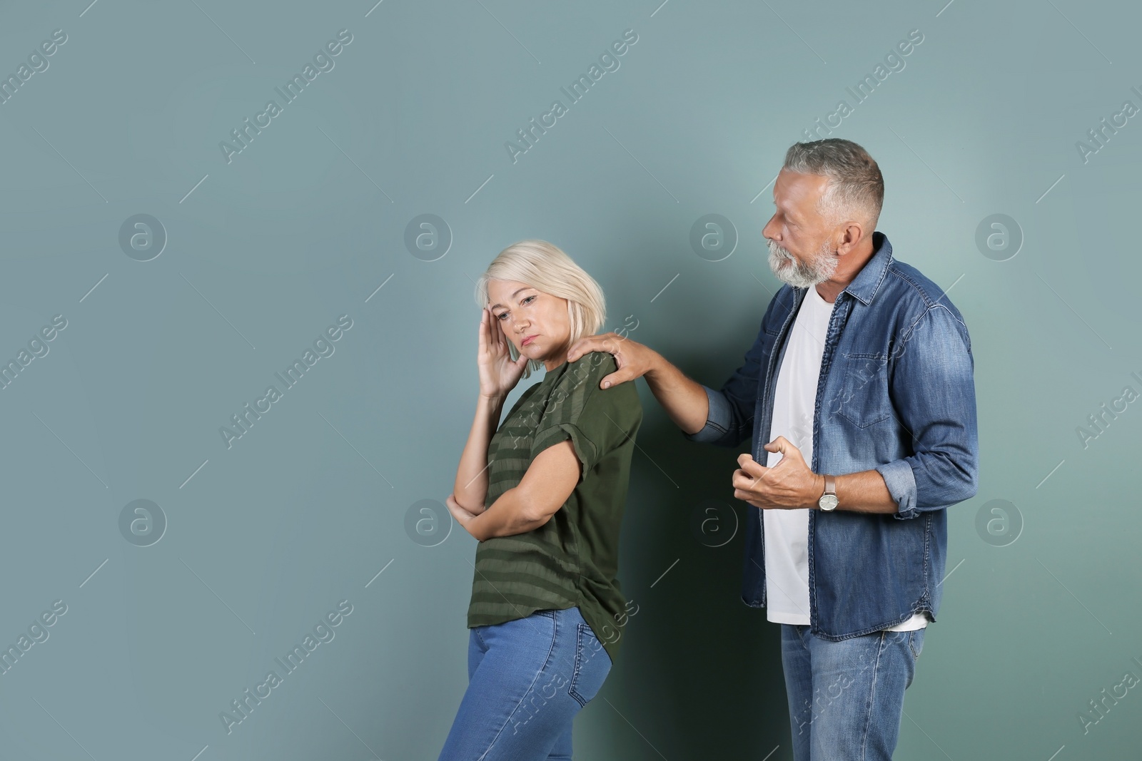 Photo of Mature couple having argument on color background. Relationship problems