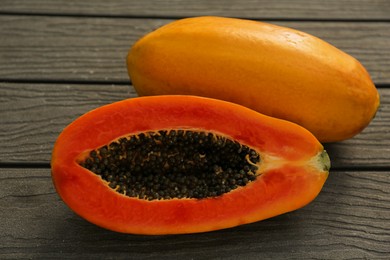 Photo of Fresh ripe papaya fruits on wooden table, above view