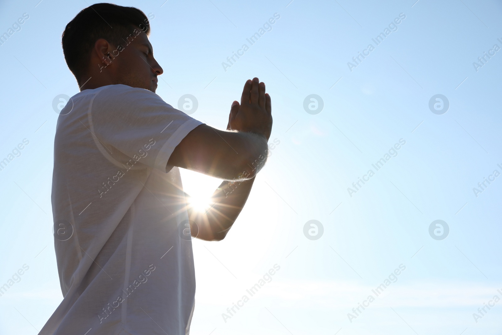 Photo of Man meditating against blue sky, space for text. Nature healing power